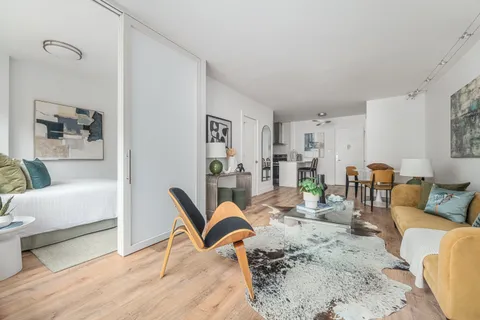 a living room with furniture and wooden floor