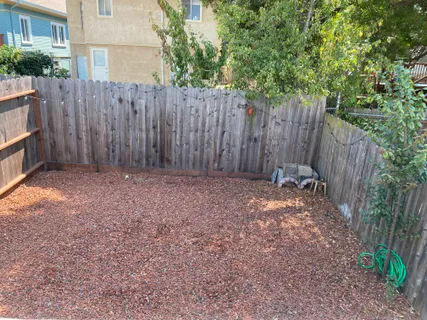 a view of backyard with wooden fence