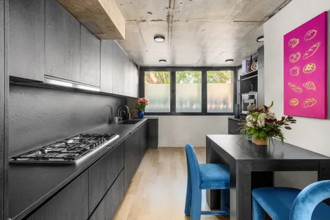 a kitchen with stainless steel appliances kitchen island granite countertop a stove a sink dishwasher and cabinets with wooden floor