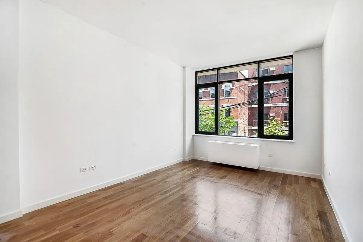 142 North 6th Street, Unit 3B Brooklyn, NY 11249 - Photo 2 of 7 a view of an empty room with wooden floor and a window