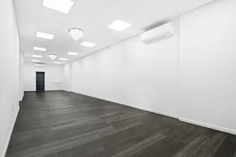 a view of a room with wooden floor and a window