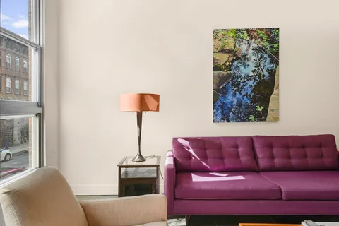 a living room with furniture and a lamp