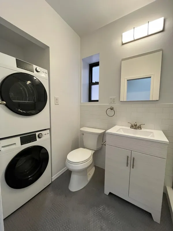 a bathroom with a toilet sink and mirror