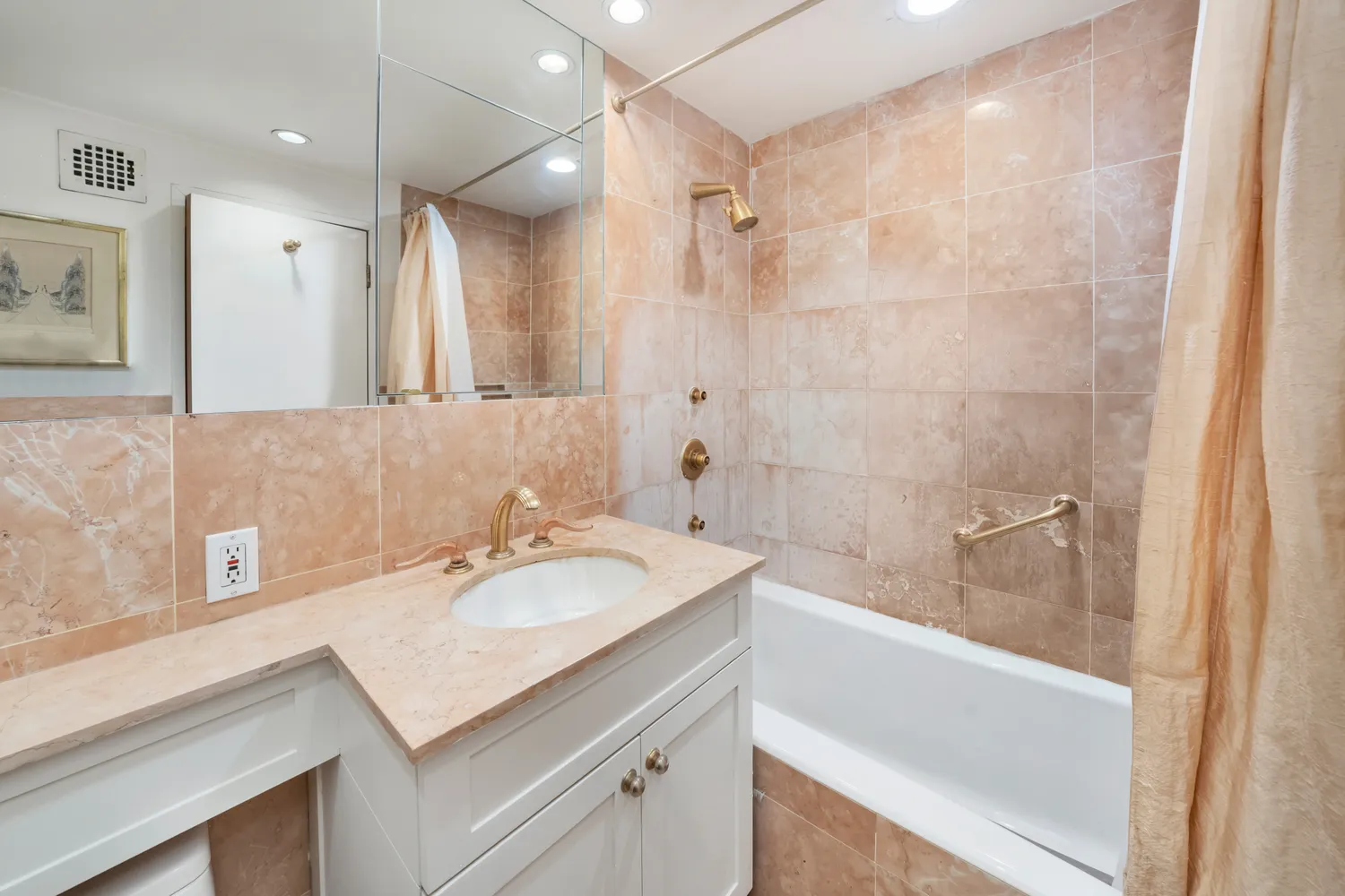 a bathroom with a sink a vanity a bathtub and a shower