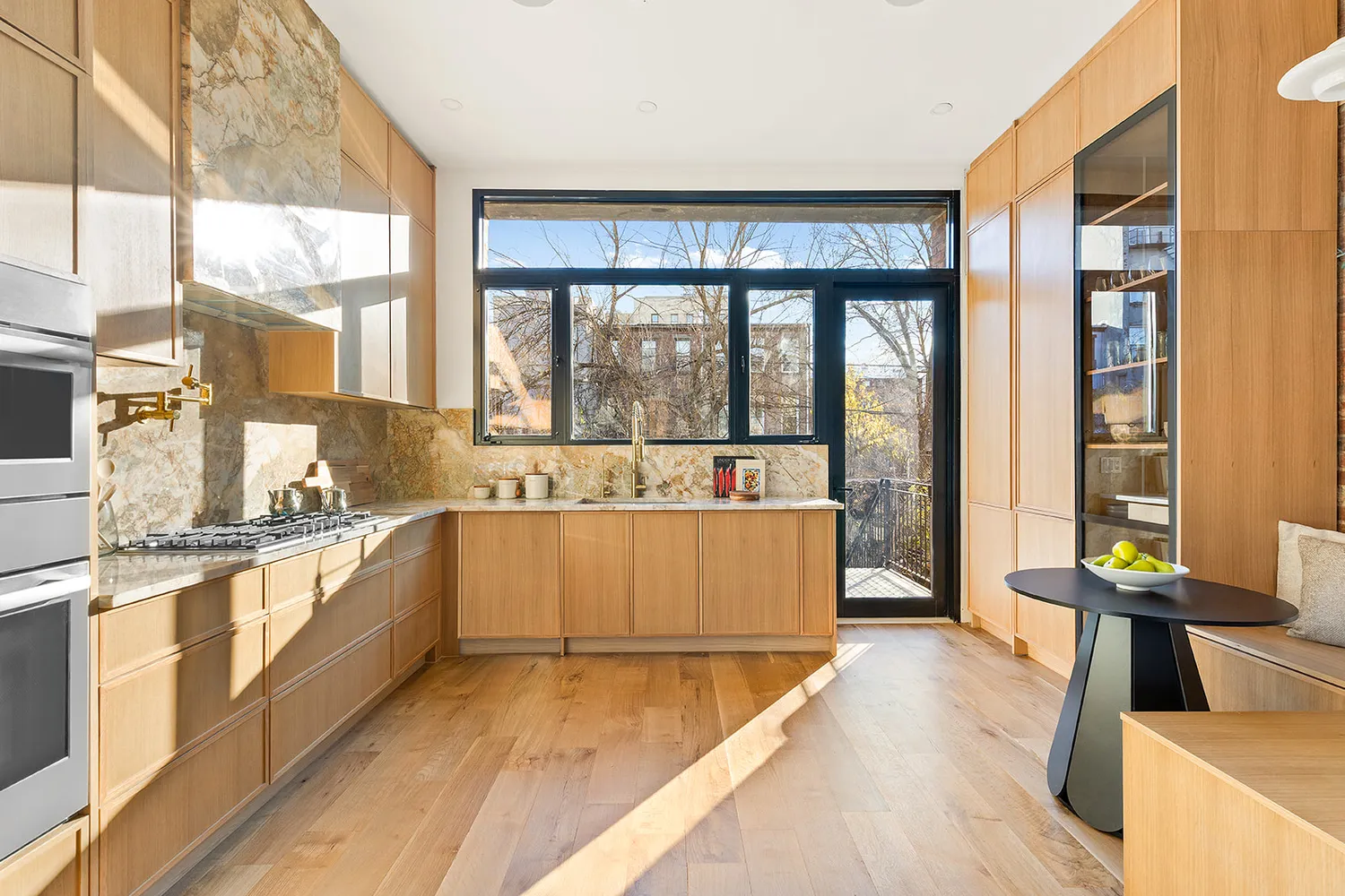 a large white kitchen with granite countertop a large window and a counter space
