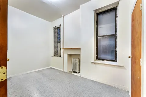 an empty room with windows and fireplace