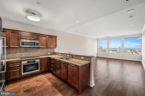 a kitchen with stainless steel appliances granite countertop a stove a sink and a microwave