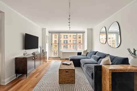 a living room with furniture a flat screen tv and a floor to ceiling window