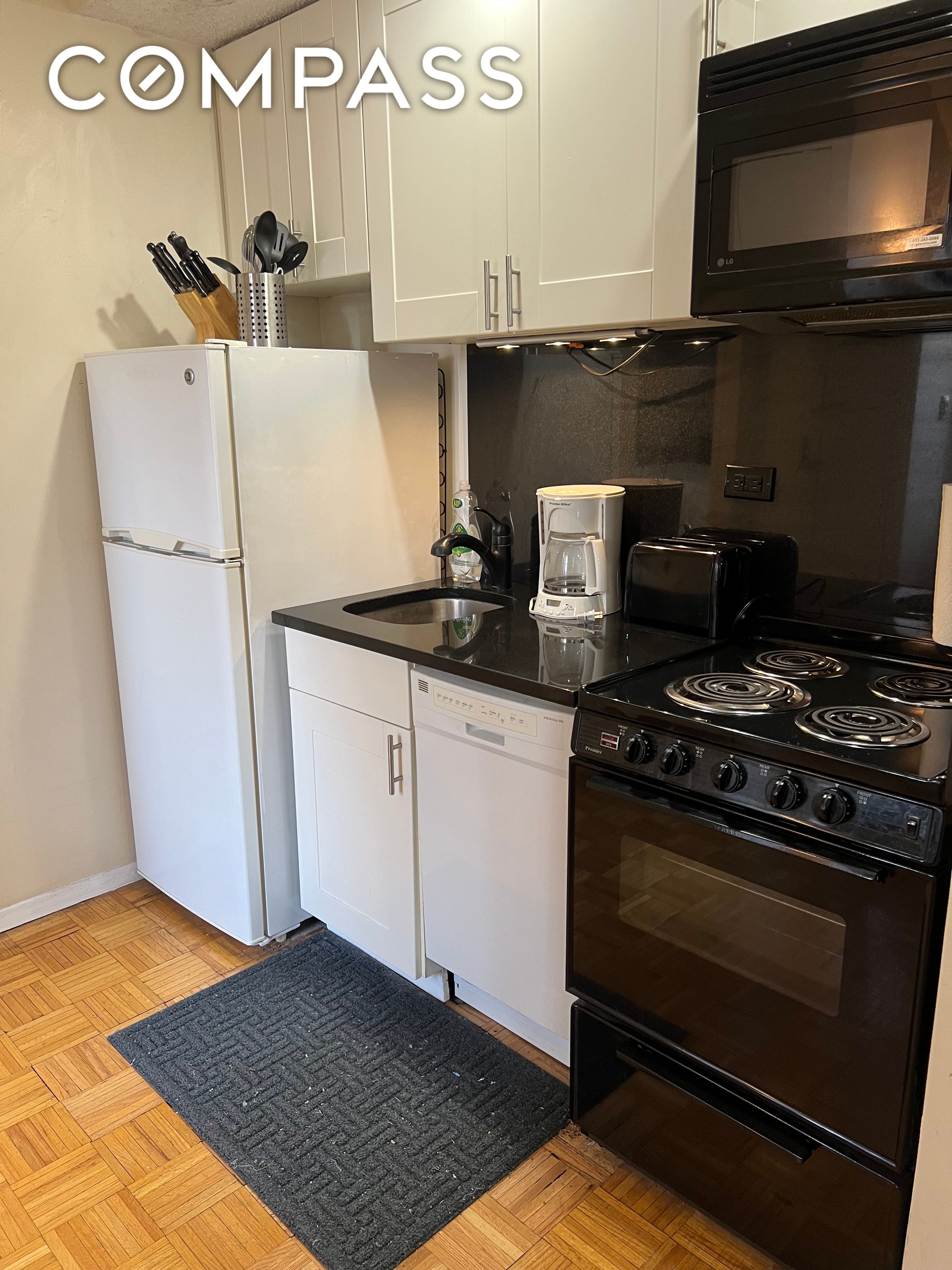 150 West 51st Street, Unit 1909 Manhattan, NY 10019 - Photo 5 of 12 a kitchen with a stove and a microwave