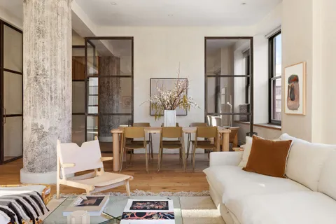 a living room with furniture fireplace and a large window