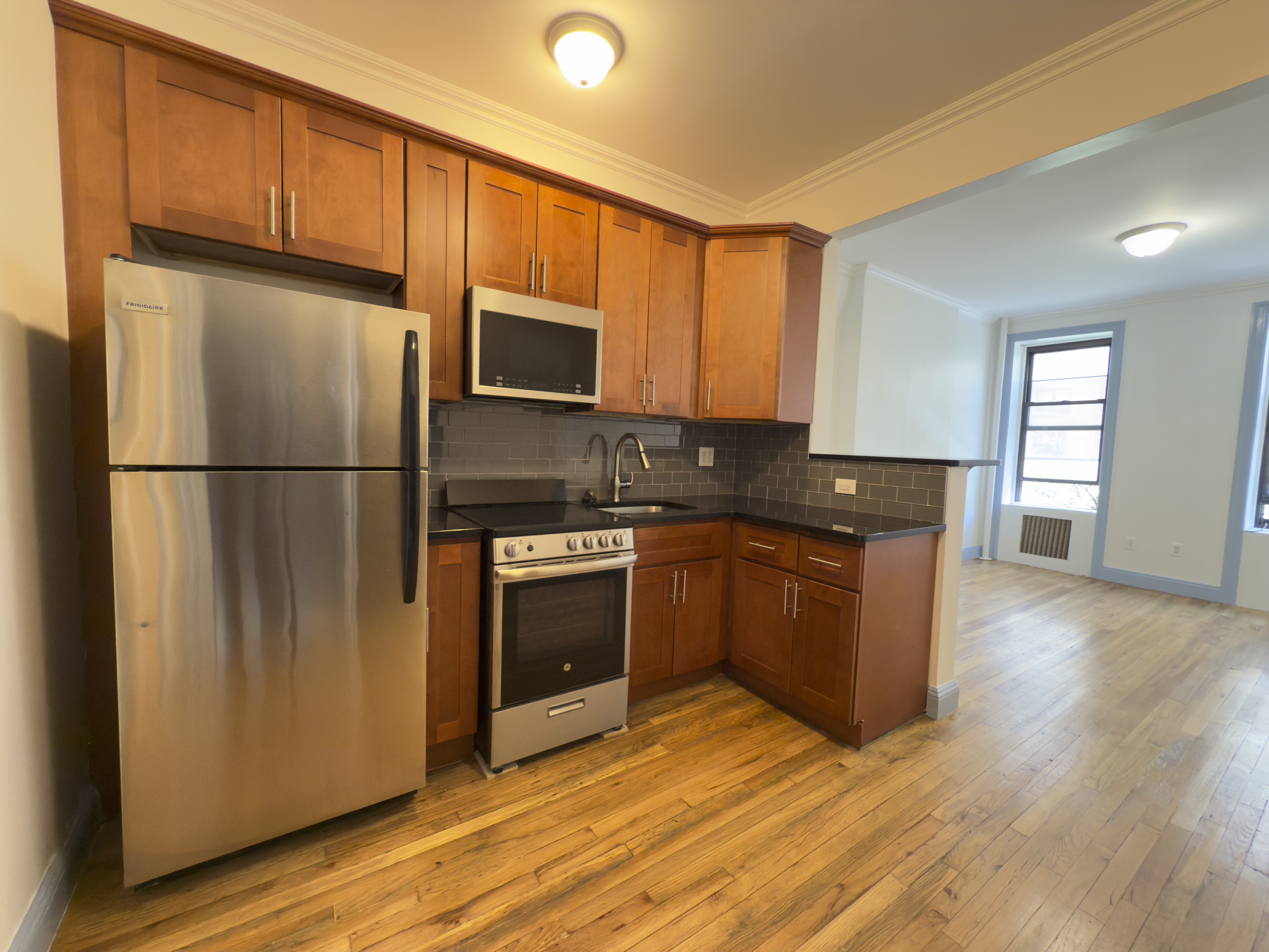 a kitchen with stainless steel appliances granite countertop a refrigerator a stove a sink and a microwave