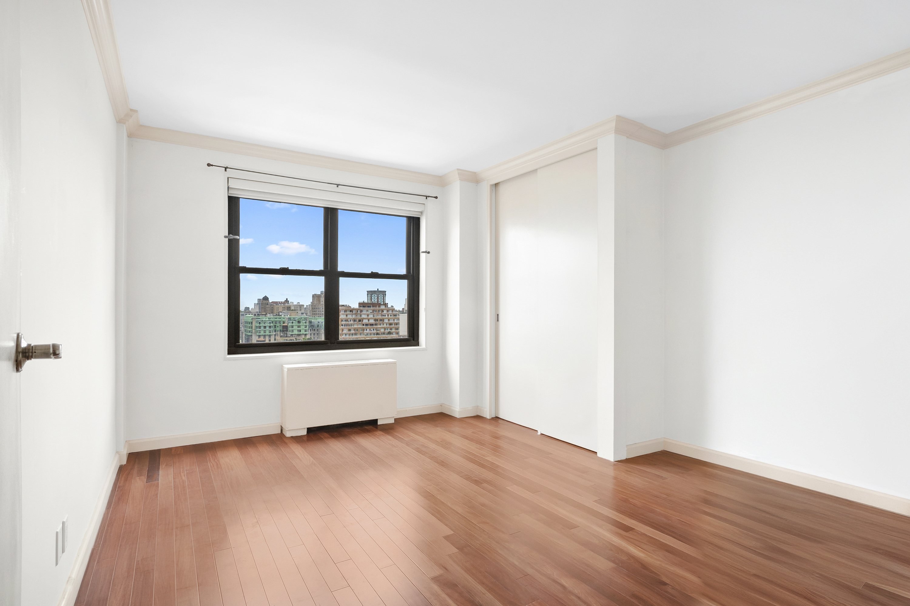180 West End Avenue, Unit 28S Manhattan, NY 10023 - Photo 5 of 10 an empty room with wooden floor and windows