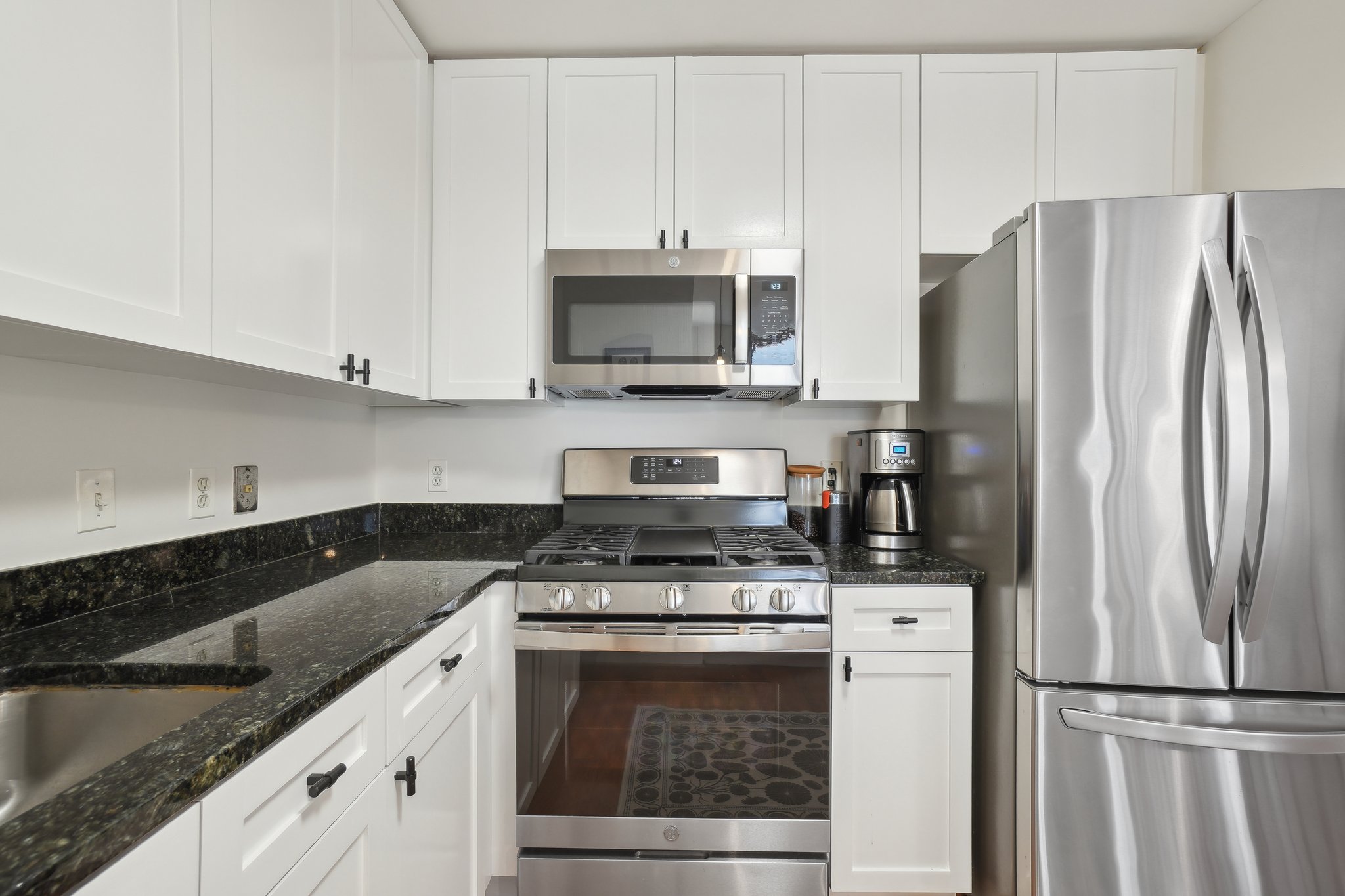 2120 Vermont Avenue Northwest, Unit 309 Washington, DC 20001 - Photo 10 of 26 a kitchen with granite countertop a refrigerator stove and microwave