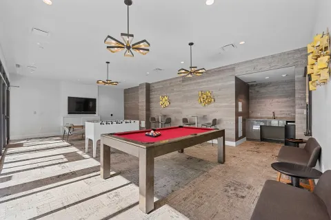 a living room with furniture pool table and a flat screen tv
