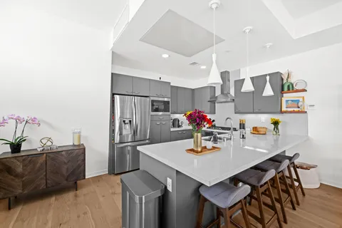 a kitchen with stainless steel appliances granite countertop a sink refrigerator and cabinets