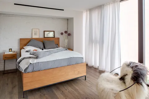 a bed sitting in a bedroom next to a window