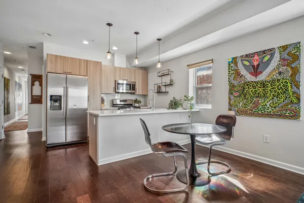 a kitchen with stainless steel appliances granite countertop a refrigerator a stove a sink dishwasher with a dining table and chair