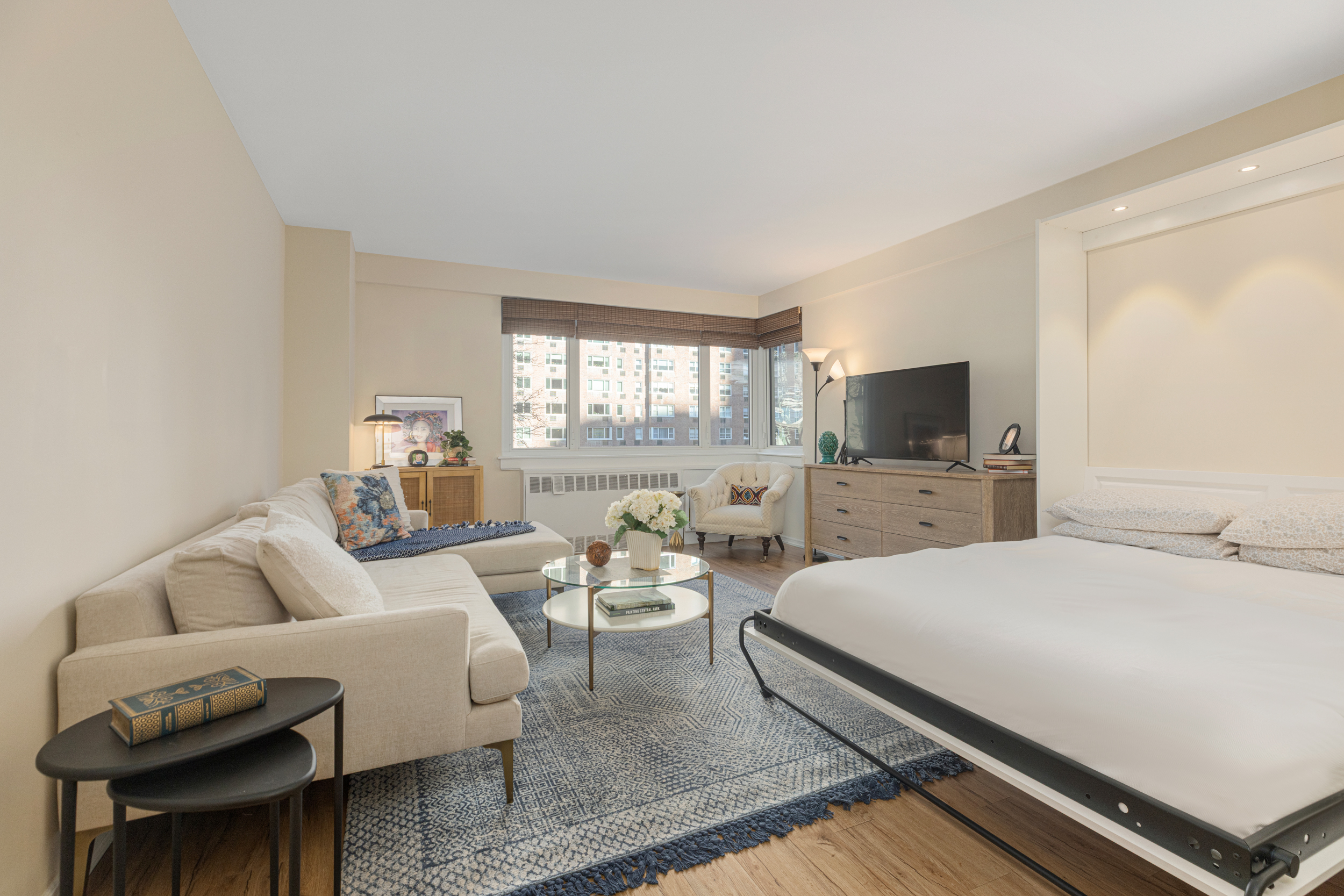 345 West 58th Street, Unit 4Y Manhattan, NY 10019 - Photo 3 of 12 a bedroom with a bed and a flat screen tv