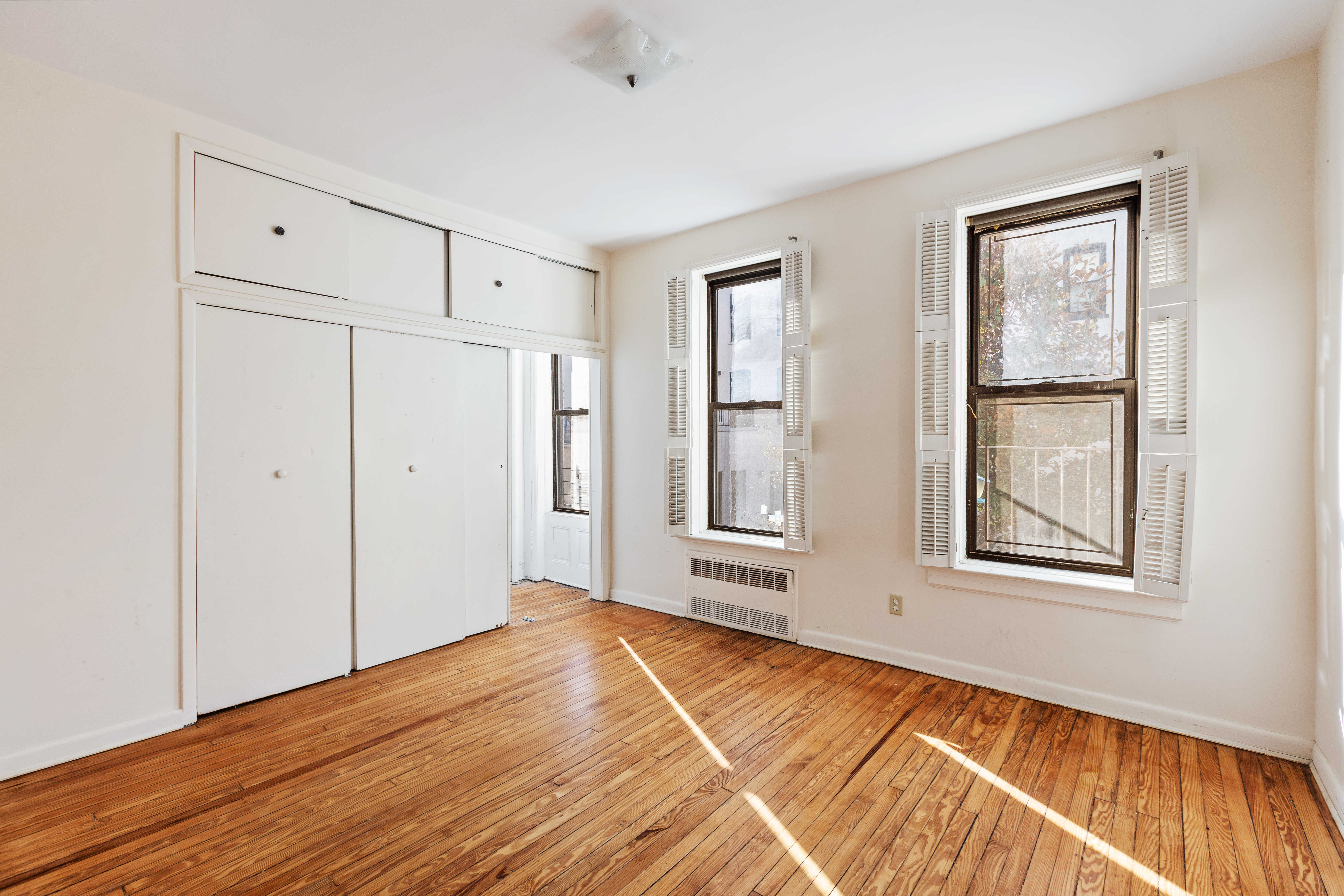 474 3rd Street, Unit 2L Brooklyn, NY 11215 - Photo 7 of 11 a view of an empty room with wooden floor and a window