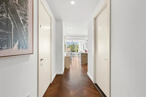 a view of a hallway with a dining table & chairs