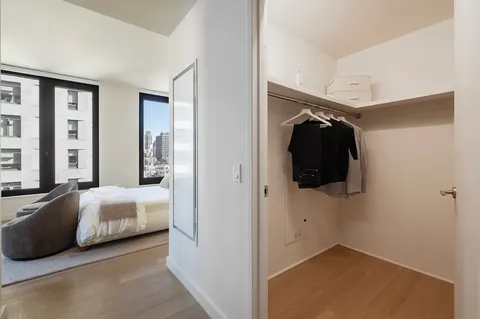 a view of a bedroom with bed and walk in closet