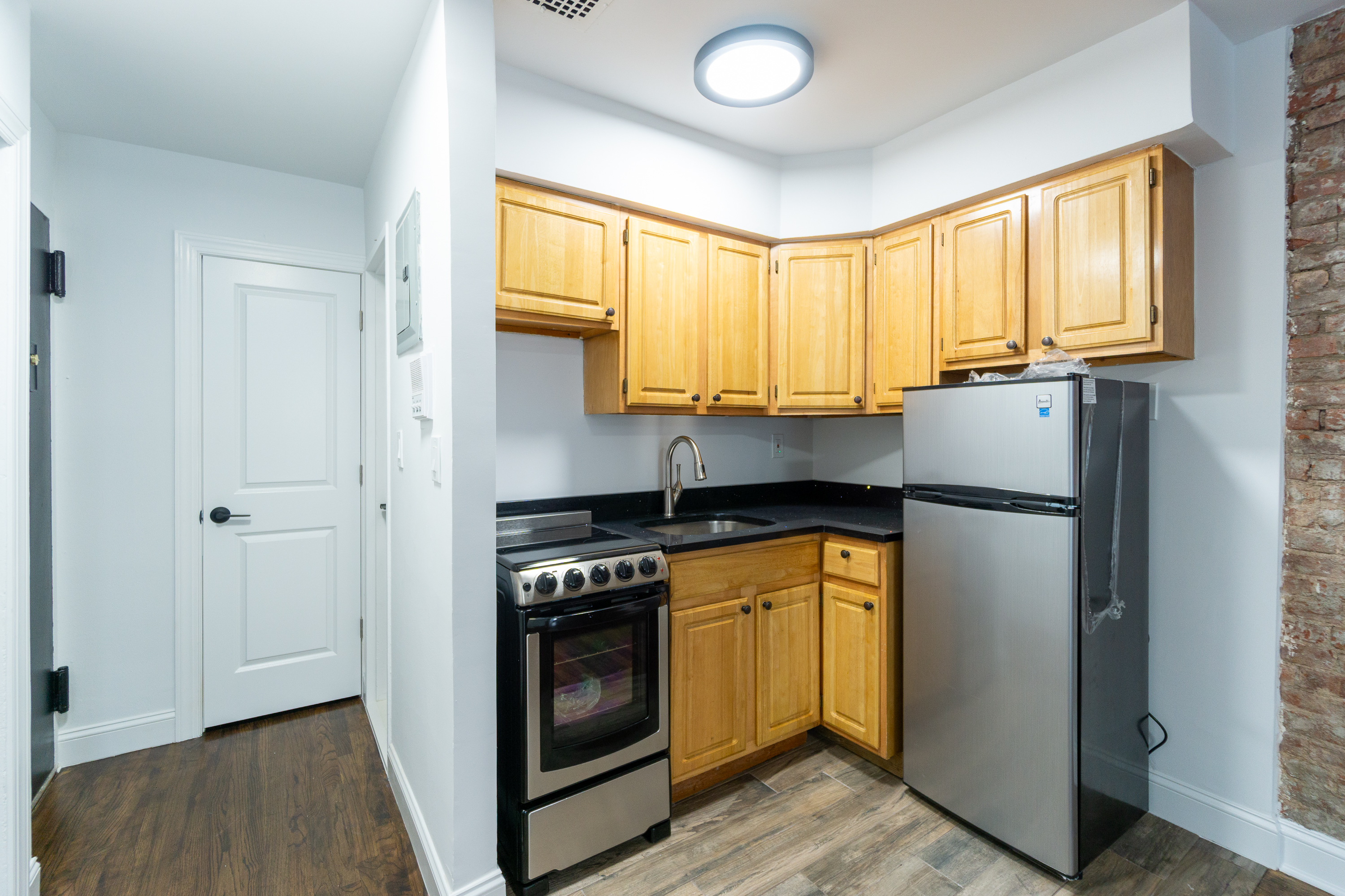 205 2nd Avenue, Unit 3B Manhattan, NY 10003 - Photo 7 of 9 a kitchen with stainless steel appliances granite countertop a refrigerator a stove and a window