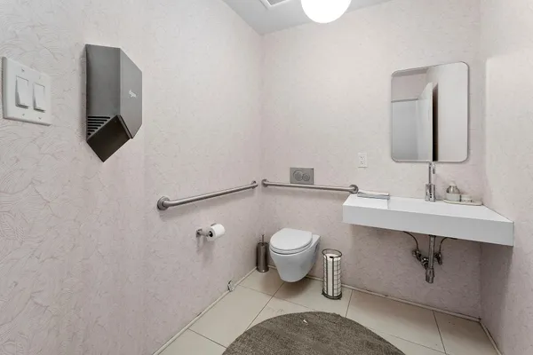 a bathroom with a sink toilet and mirror