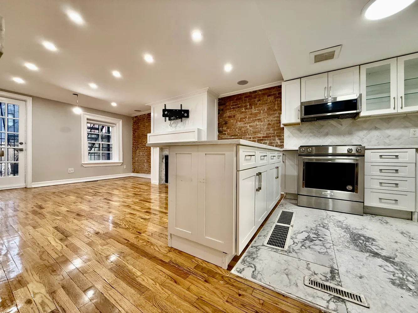 a kitchen with stainless steel appliances granite countertop a stove a sink and a microwave