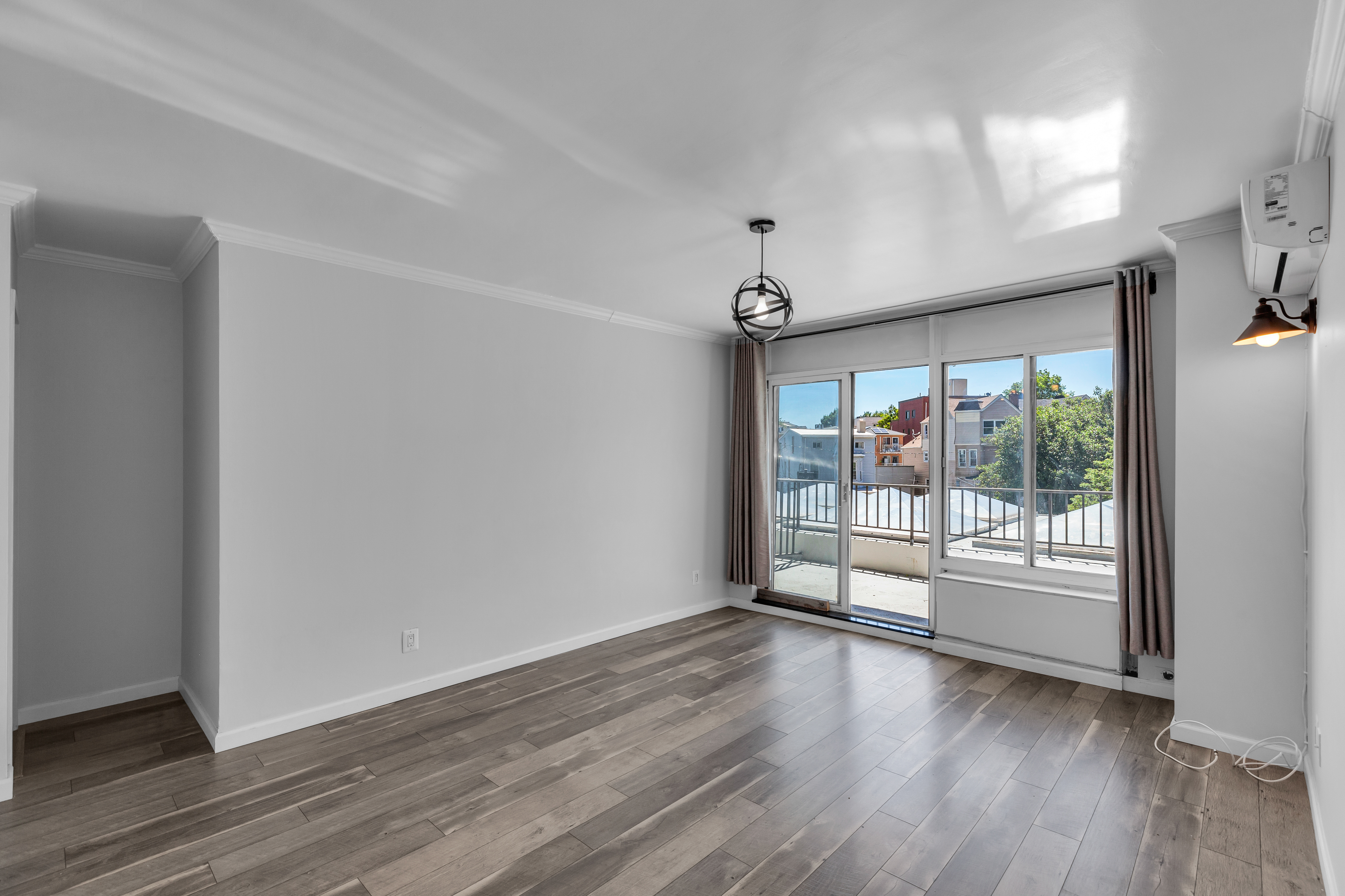 25-40 Shore Boulevard, Unit 2F Queens, NY 11102 - Photo 2 of 31 wooden floor in an empty room with a window