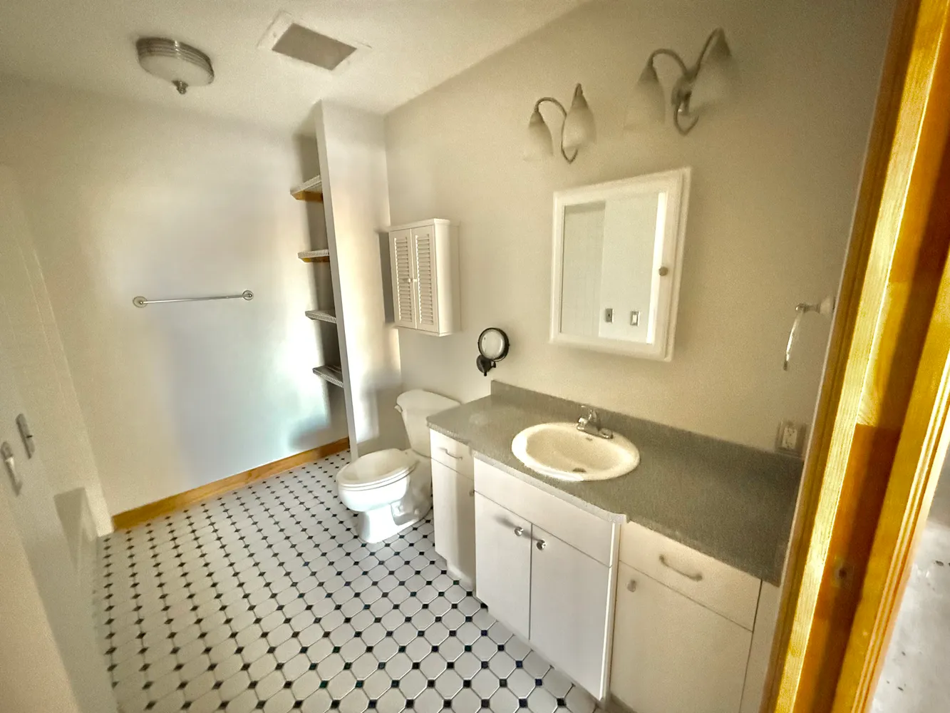 a bathroom with a granite countertop sink toilet and shower