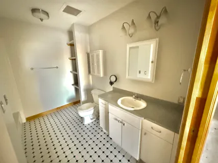 a bathroom with a granite countertop sink toilet and shower