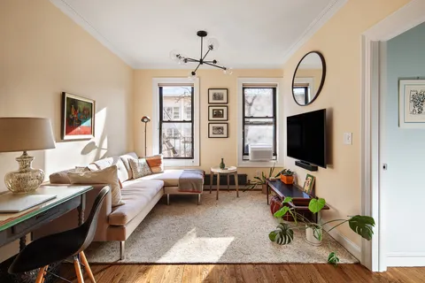 a living room with furniture a flat screen tv and a large window