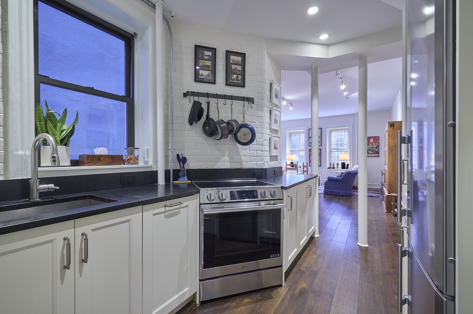 227 West 11th Street, Unit 2 Manhattan, NY 10014 - Photo 4 of 8 a kitchen with a stove and a wooden floor