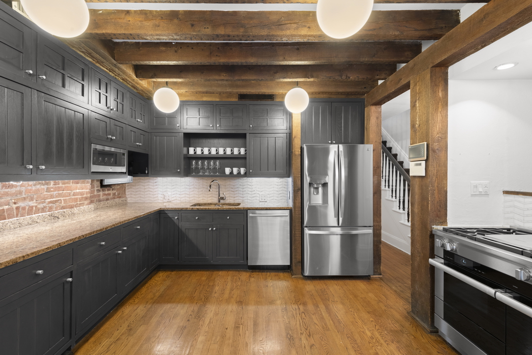 209 East 61st Street Manhattan, NY 10065 - Photo 23 of 27 a kitchen with stainless steel appliances granite countertop a refrigerator a sink and a stove