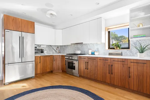 a kitchen with stainless steel appliances granite countertop a refrigerator sink and wooden cabinets
