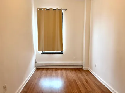 a view of a room with wooden floor and window