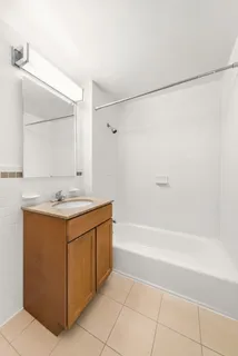 a bathroom with a sink mirror vanity and bathtub