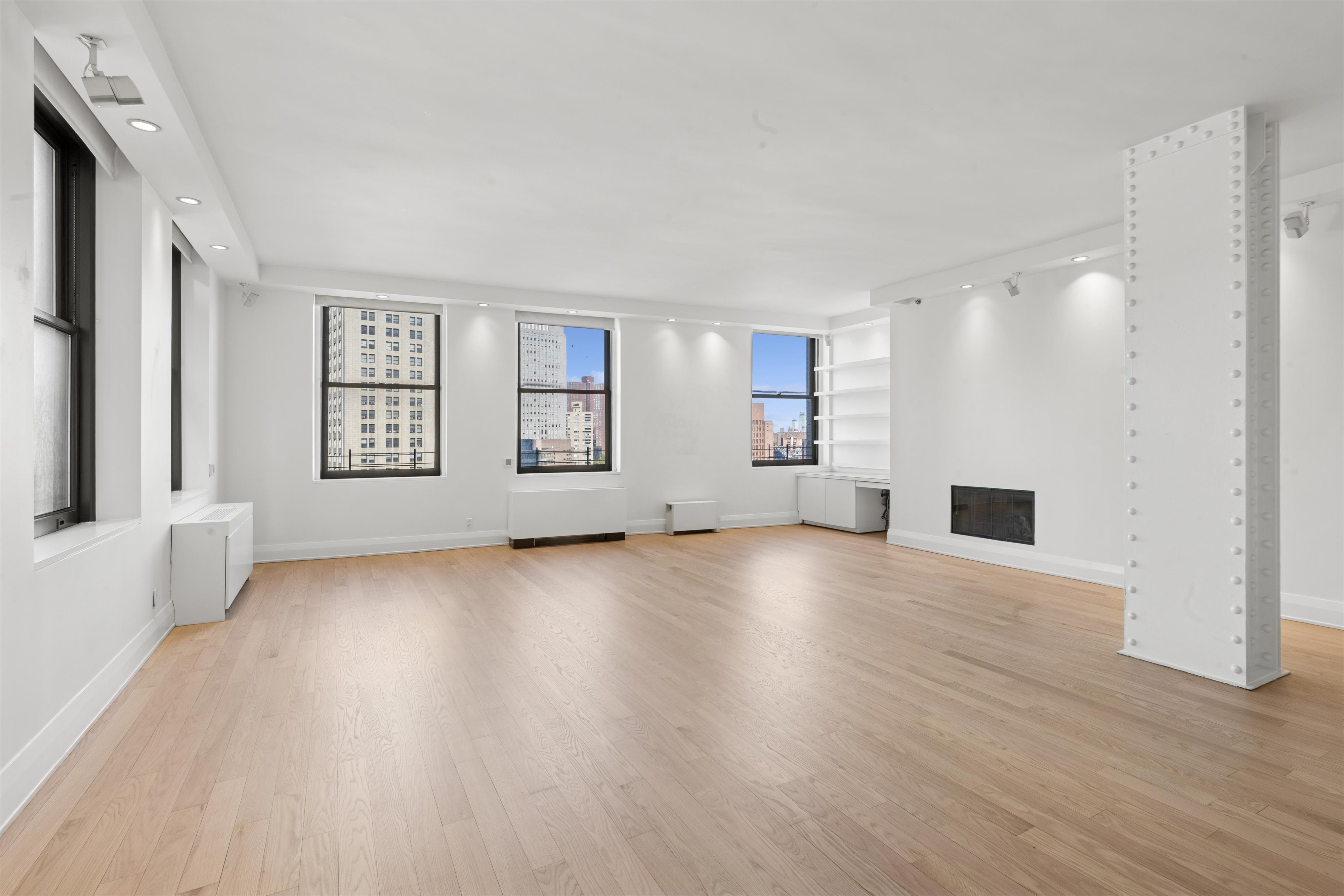 150 Nassau Street, Unit 11B Manhattan, NY 10038 - Photo 2 of 17 a view of an empty room with a window and wooden floor