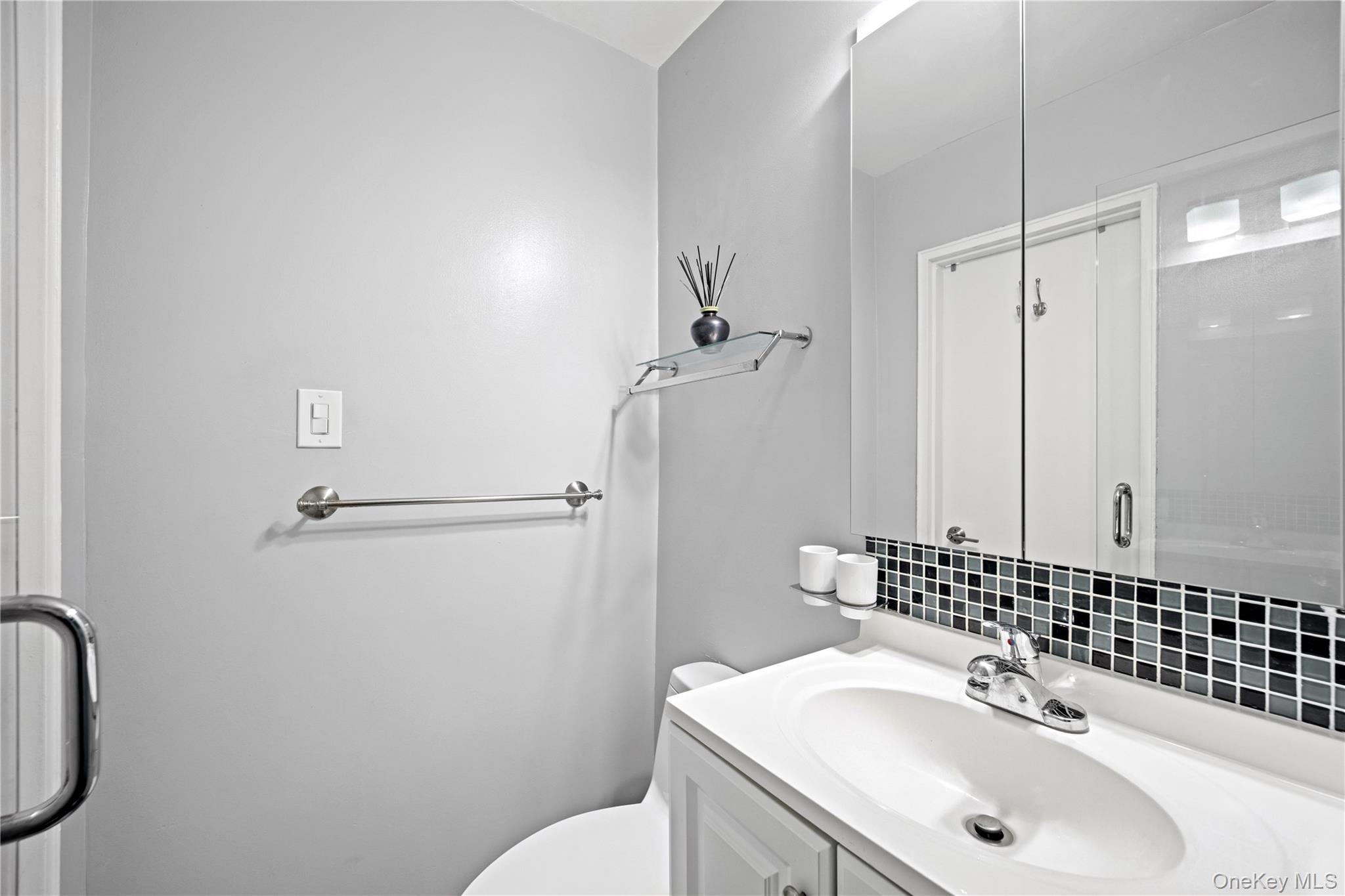 75-34 Bell Boulevard, Unit LD Queens, NY 11364 - Photo 12 of 26 a bathroom with a sink toilet and shower