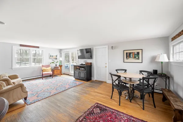 a living room with furniture kitchen view and a window