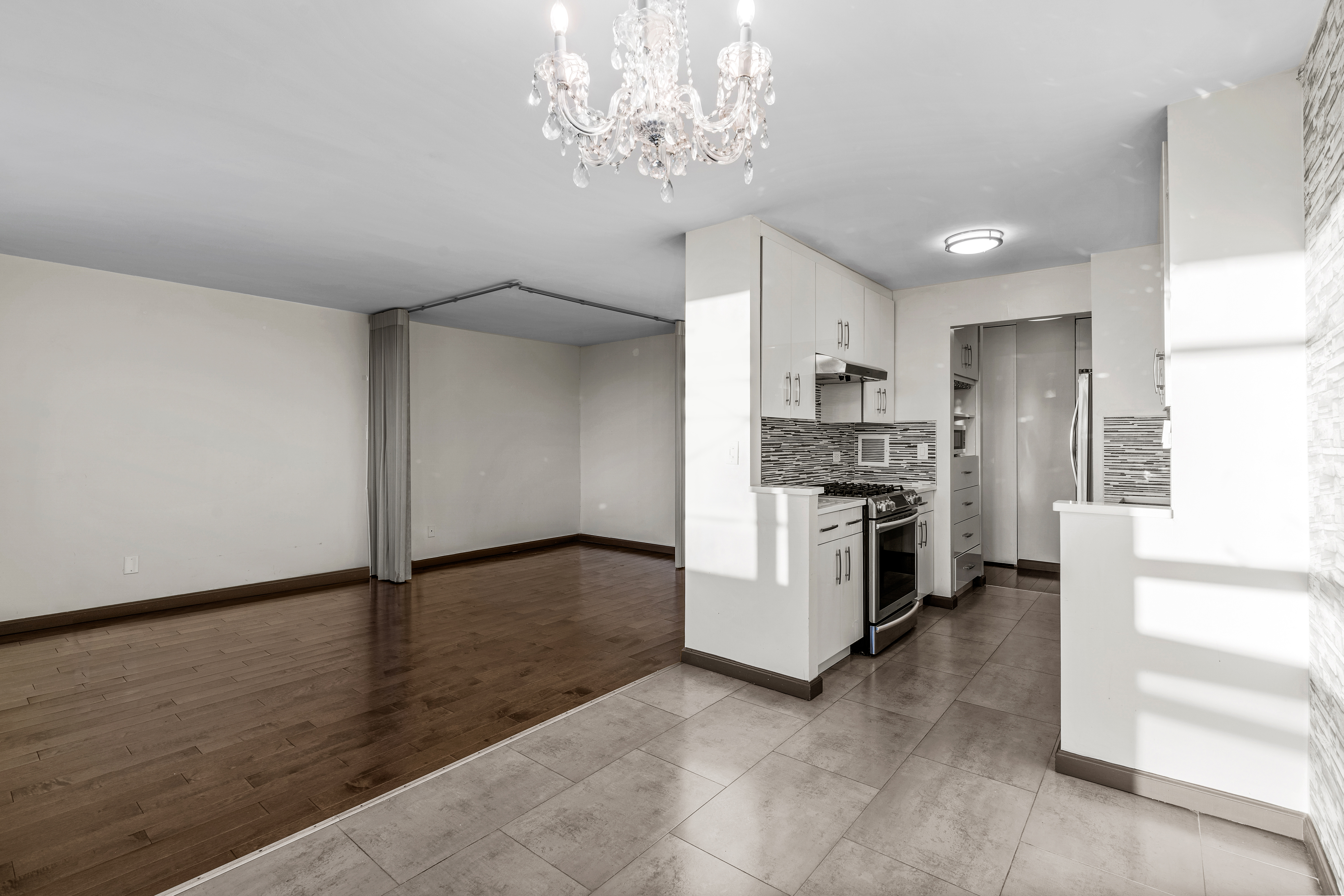 112-01 Queens Boulevard, Unit 7E Queens, NY 11375 - Photo 12 of 27 a kitchen with granite countertop a refrigerator and a stove top oven