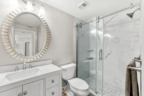 a bathroom with a sink a toilet and shower
