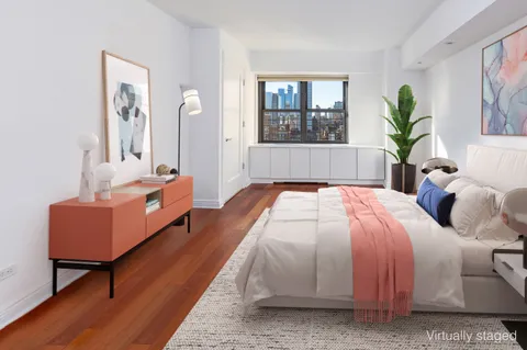 a spacious bedroom with a bed a couch and windows