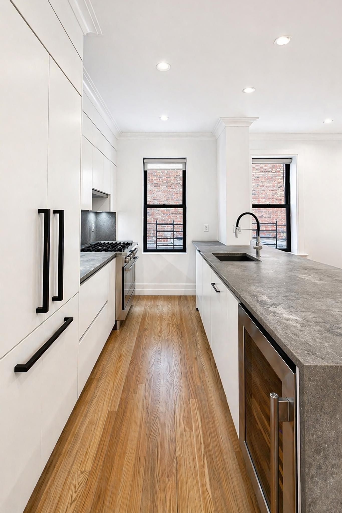 24-39 38th Street, Unit B10B9 Queens, NY 11103 - Photo 14 of 20 a large kitchen with granite countertop a lot of counter space and wooden floor