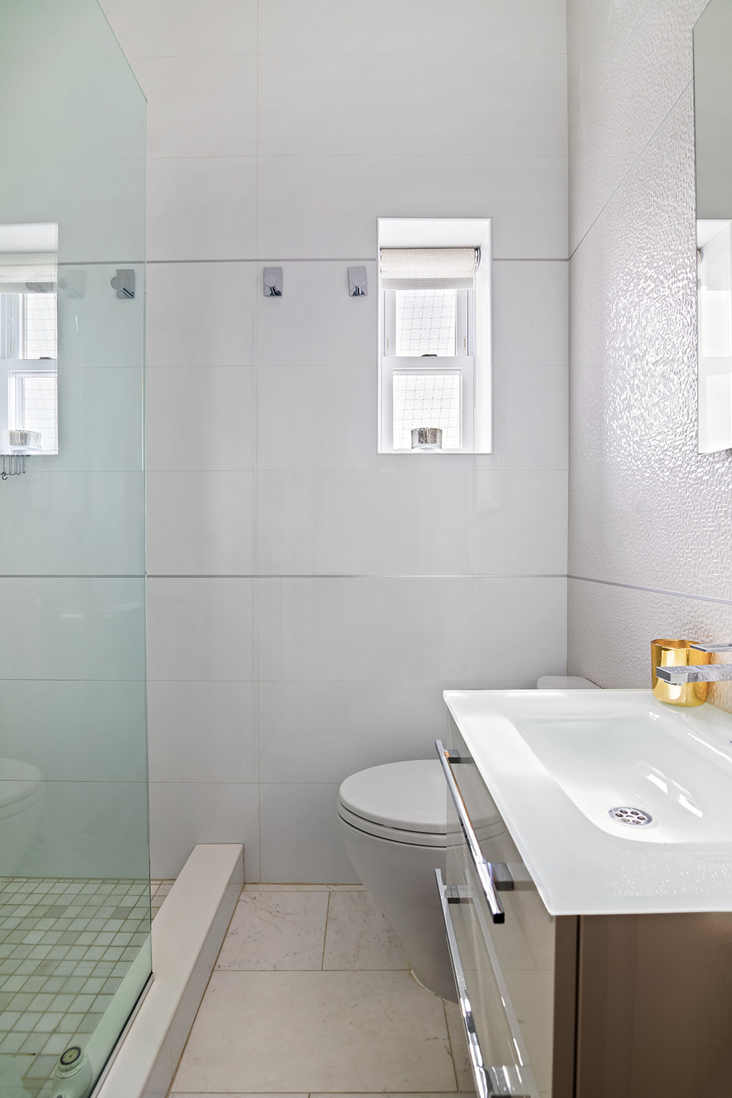 77 Perry Street, Unit 6CD Manhattan, NY 10014 - Photo 11 of 16 a bathroom with a sink a toilet and a mirror