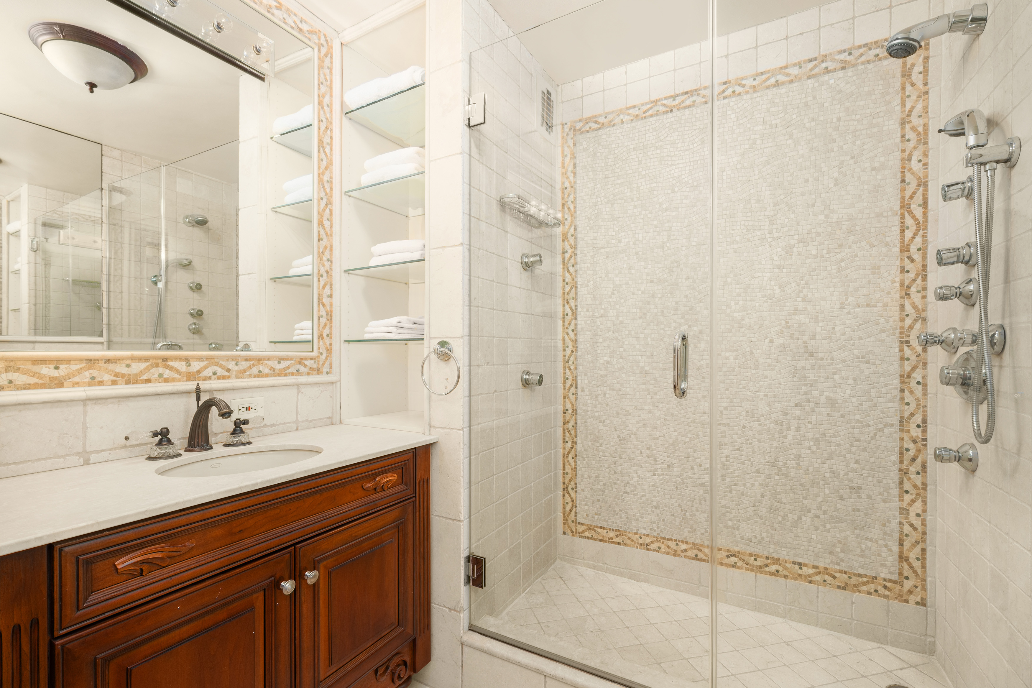 207 East 74th Street, Unit 11E Manhattan, NY 10021 - Photo 12 of 20 a bathroom with a shower sink and mirror