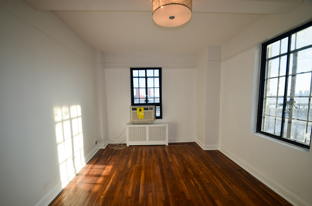5 Tudor City Place, Unit A15 Manhattan, NY 10017 - Photo 7 of 8 wooden floor in an empty room with a window