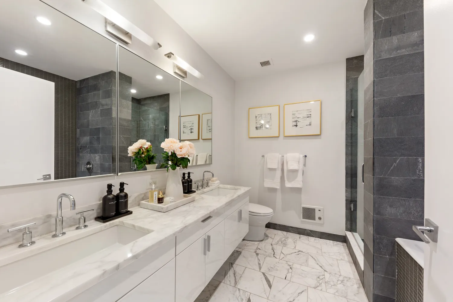 a bathroom with a double vanity sink mirror and shower