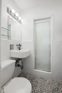 a bathroom with a sink a toilet and shower