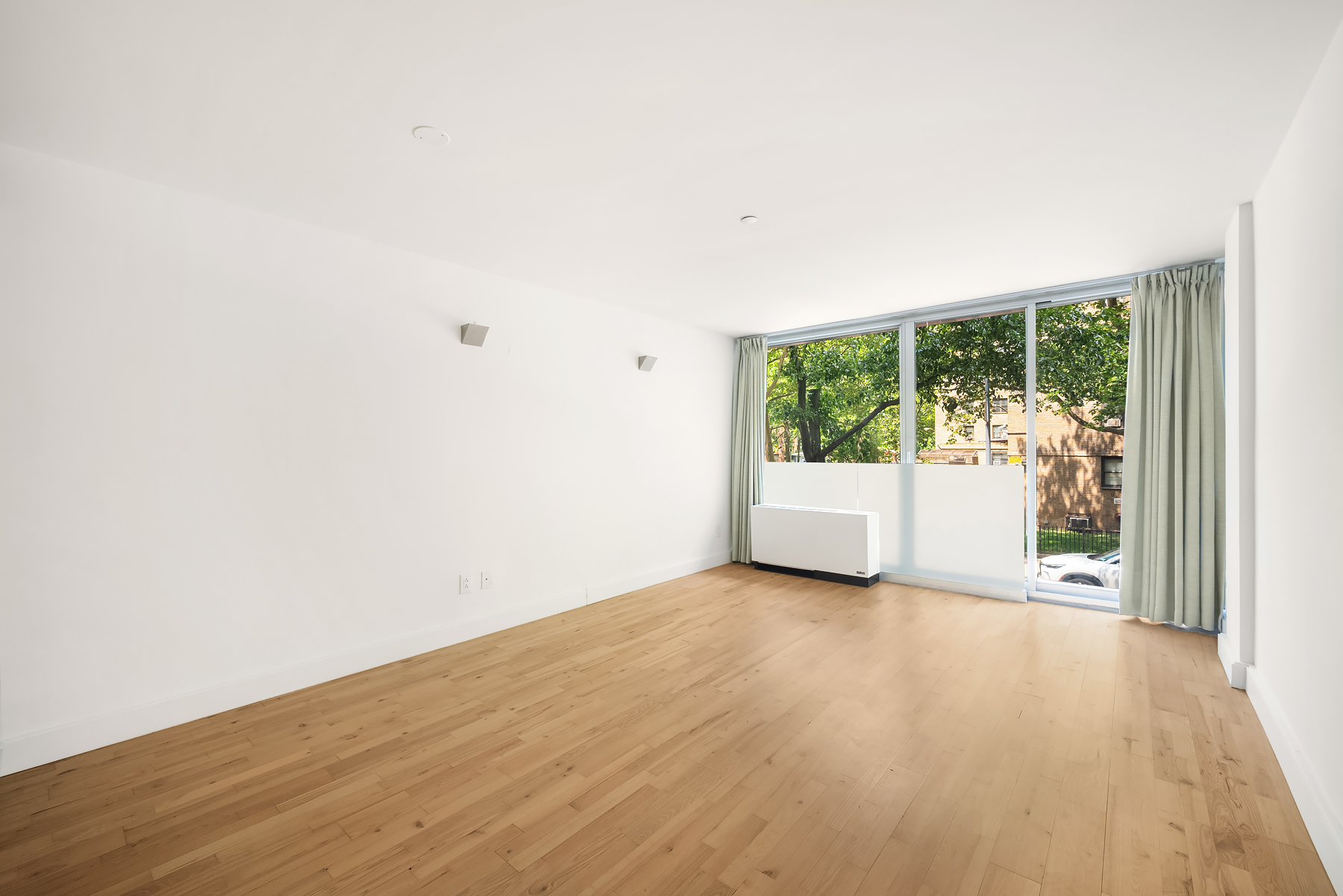 420 West 25th Street, Unit 2K Manhattan, NY 10001 - Photo 6 of 18 a view of a room with wooden floor and window